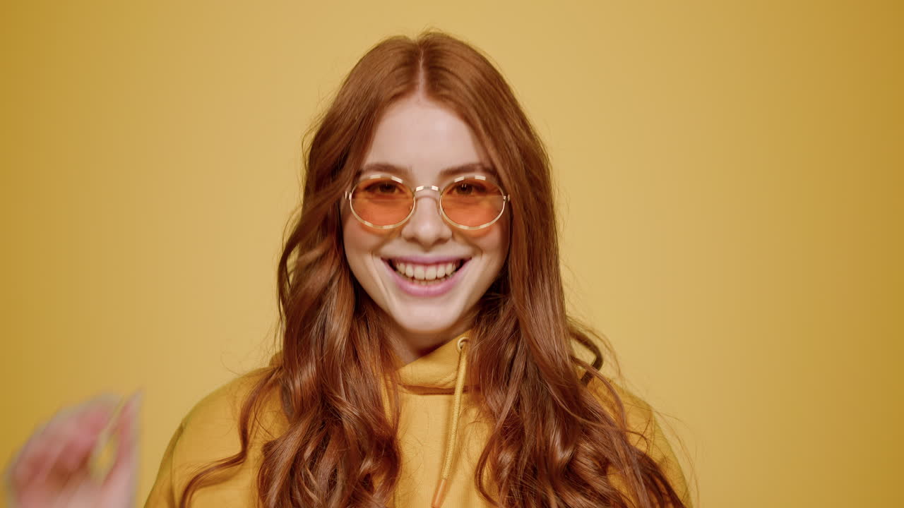 persona femenina juguetona que actúa en el interior. chica dulce que usa gafas en el estudio