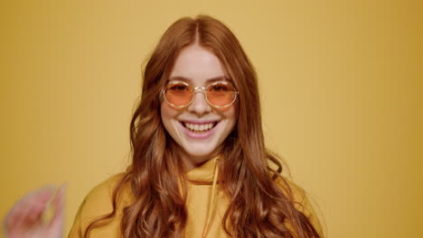 playful female person acting indoors. sweet girl wearing eyeglasses in studio