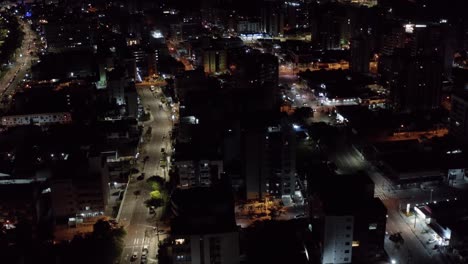 incline hacia arriba la toma nocturna de drones aéreos de la ciudad capital de la playa tropical de joao pessoa, paraiba, brasil desde el barrio de tambaú con rascacielos, apartamentos y pequeñas calles con poco tráfico