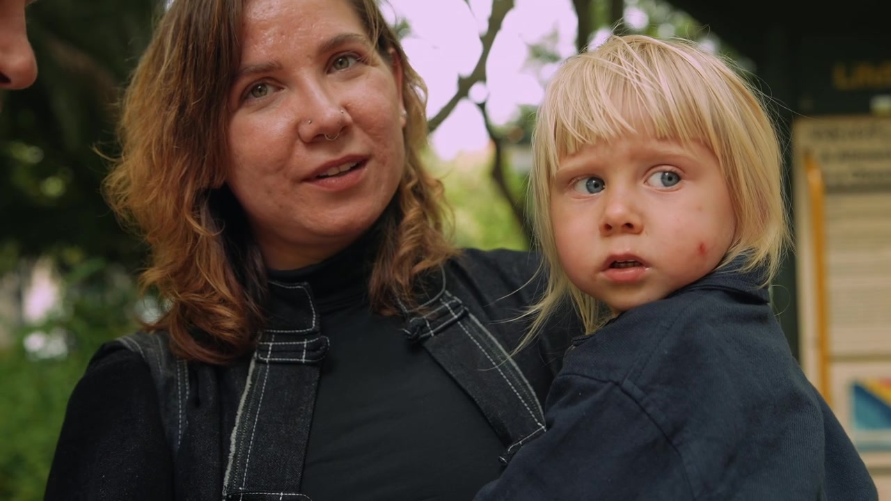 Authentischer Moment einer Familie mit Kind in einem grünen Park