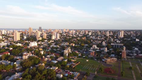 Aerial-drone-footage-of-large-city-landscape-during-sunset-in-Posadas,-Misiones,-Argentina