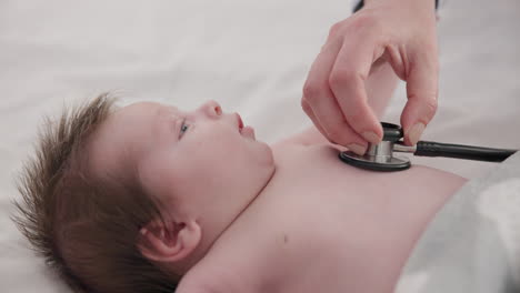 baby, stethoscope and doctor listening to heart