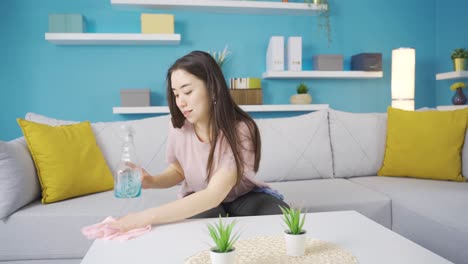 close-up view of happy asian woman wiping dust in dirty dusty house using cleaning cloth.