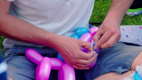 balloon artist tying balloons in park