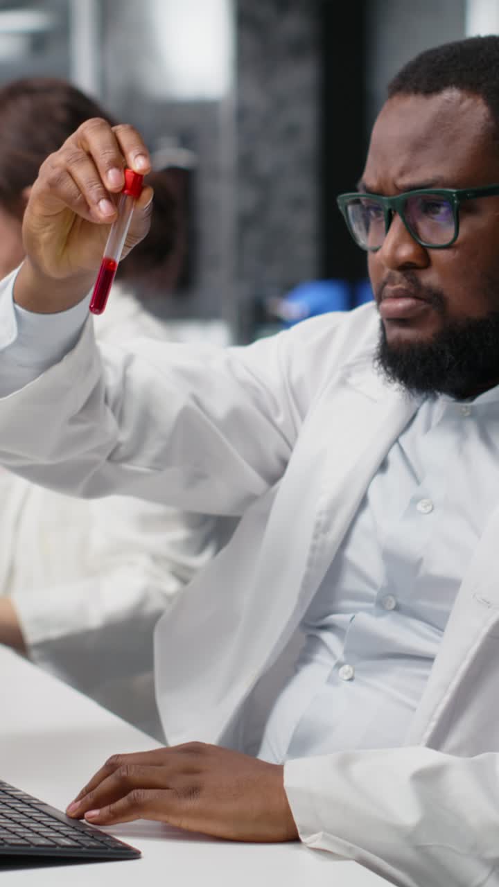Vertical video Scientist in laboratory interprets clinical blood values on computer