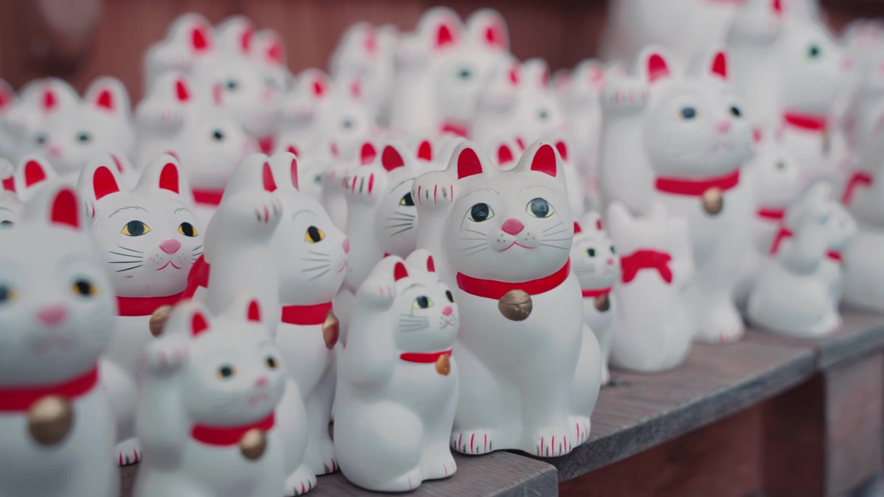 Centinaia di tradizionali statue bianche di gatti portafortuna Maneki Neko al Tempio Gotokuji, una delle attrazioni più uniche e culturalmente significative di Tokyo.