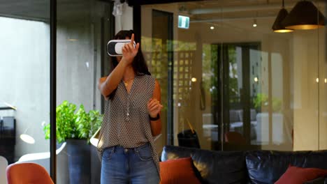 Front-view-of-young-caucasian-female-executive-using-virtual-reality-headset-in-modern-office-4k