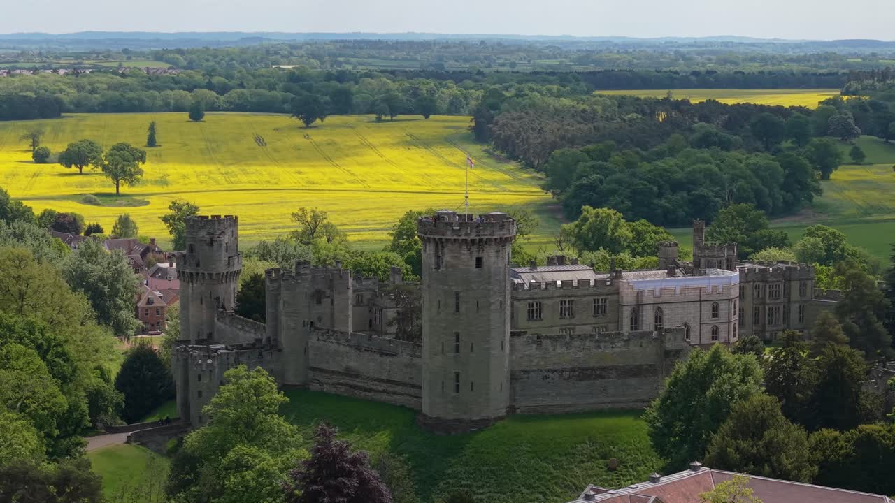 Omløpsvideo av slottets fangekjeller i Warwick, med grønne enger i bakgrunnen, som fremhever dens middelalderske arkitektur og fredelige landlige omgivelser