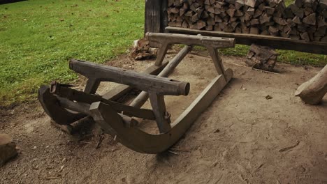 old wooden sled near stacked firewood in kumrovec village, croatia