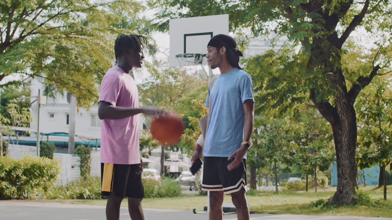 Black Sportsmen Looking at Screen of Smartphone on Streetball Playground