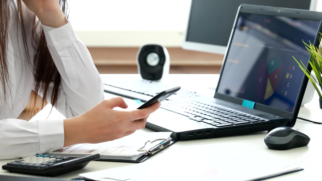 mujer de negocios que usa un teléfono inteligente en una oficina moderna