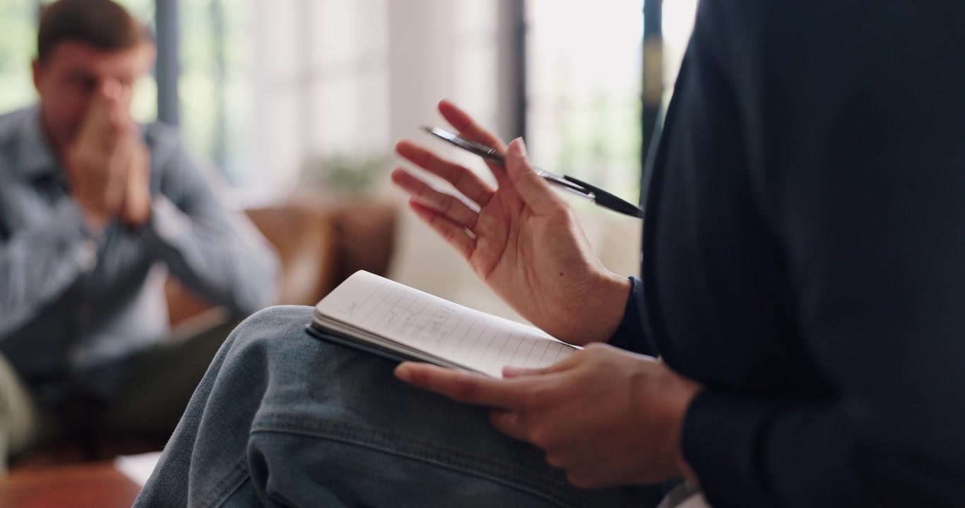 Therapist Taking Notes During Counseling Session with Distressed Patient