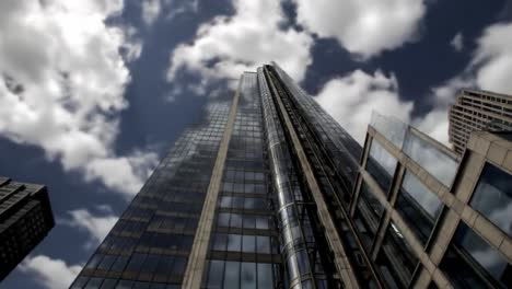 tall glass skyscrapers reach for the clouds in a dynamic cityscape. reflections shimmer on building surfaces, showcasing an architectural marvel against a backdrop of vibrant skies.