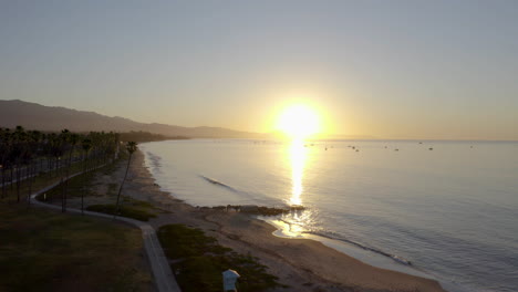 Santa-Barbara-Sonnenaufgang-Mit-Blick-Auf-Den-Ozeanhafen-Mit-Segelbootpalmen-Und-Laufpfad-Am-Strand-4k-Prores