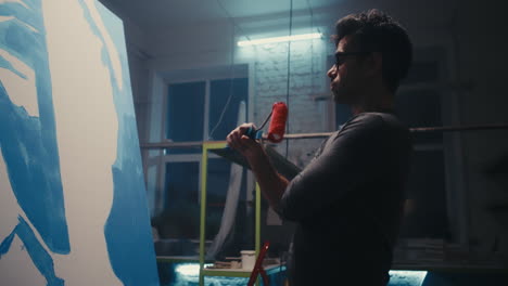artist painting in a studio at night