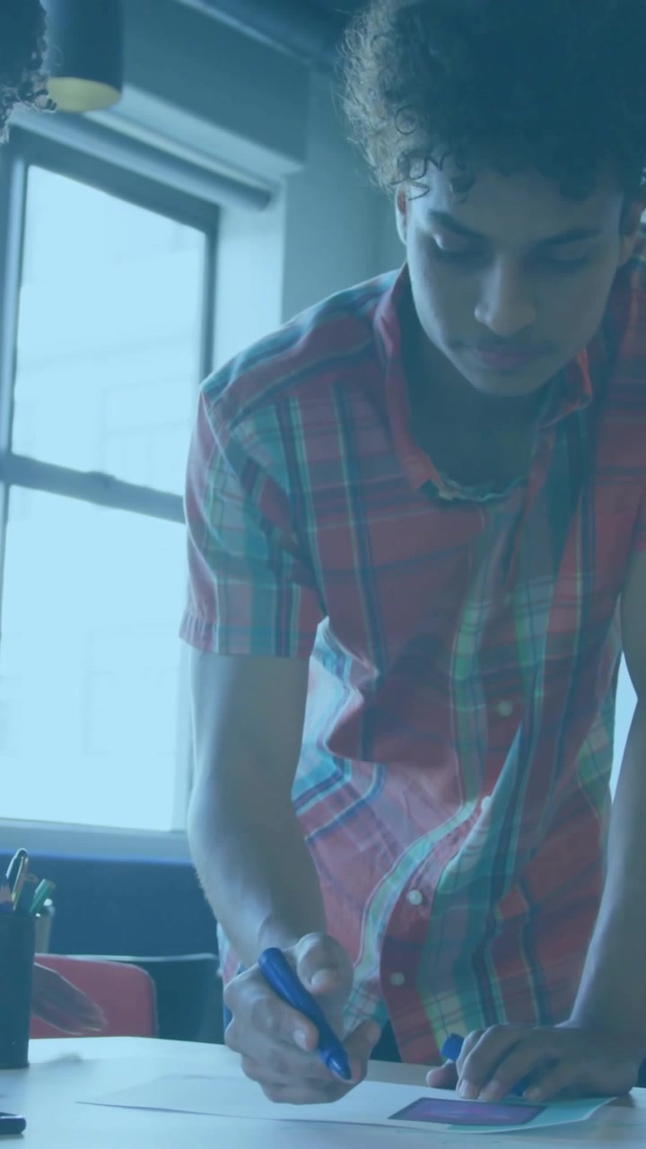 Plaid-shirt man writing on cards, second man pointing, planning business, causing bars rising