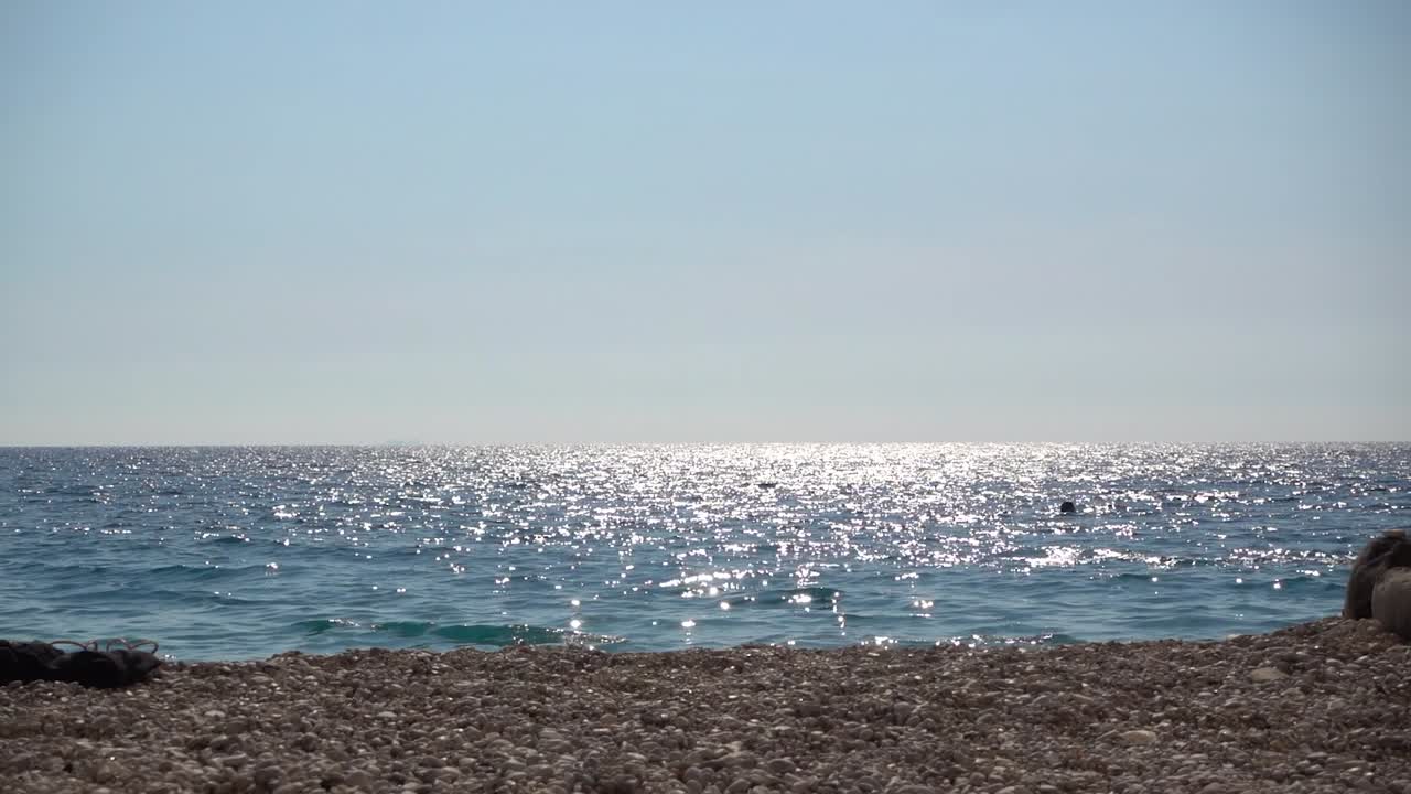 소수의 사람들이 수영하는 아름다운 반짝이는 바다 지평선
