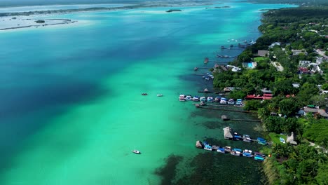 drone aerial landscape of jetty wharf boardwalk in bacalar lagoon lake with housing and resorts in rainforest town quintana roo mexico central america travel tourism