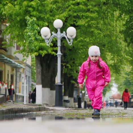 A-cheerful-girl-jumps-through-puddles-in-the-park