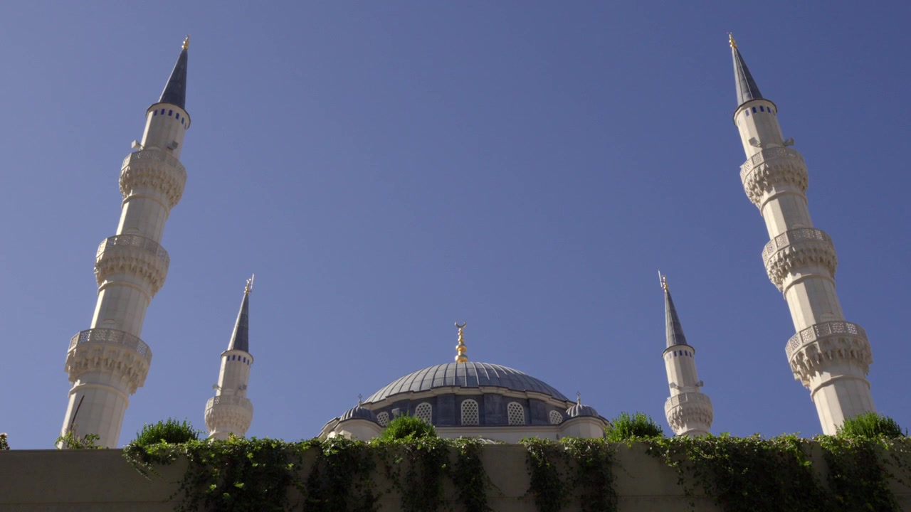 La bellissima cupola centrale e gli alti minareti della Grande Moschea di Namazgah sotto un cielo blu.