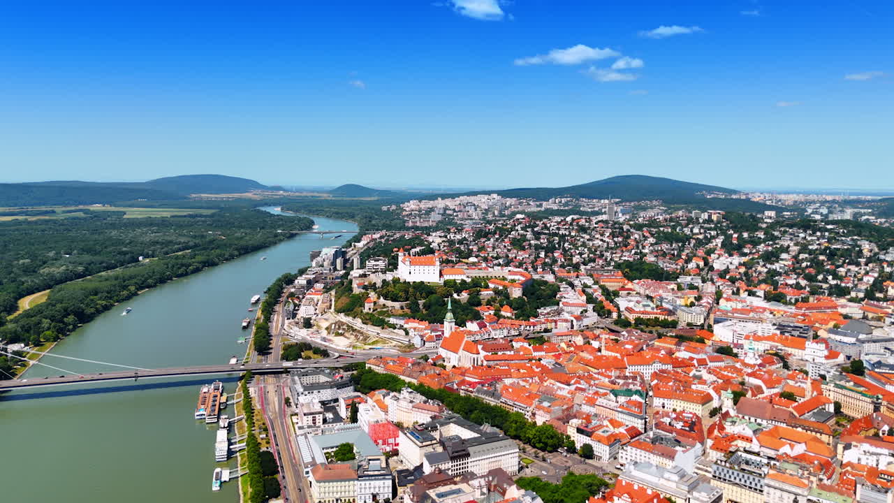 Approaching the cityscape of the old town in Bratislava, Slovakia. Beautiful Danube River crossed by some bridges. Aerial view
