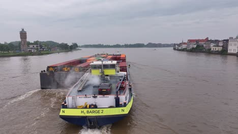 barge carrying containers on a river in the netherlands
