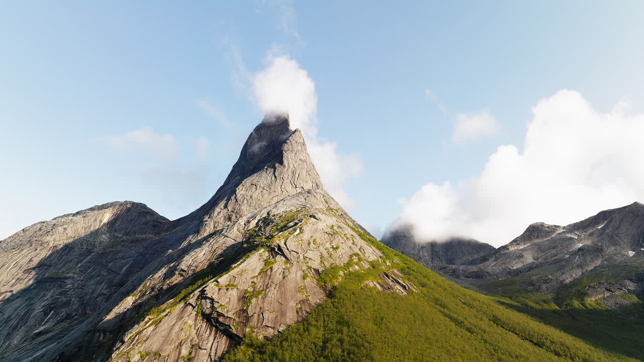 nubes rodando en el lado del viento del pico de la montaña stetind en noruega, órbita aérea