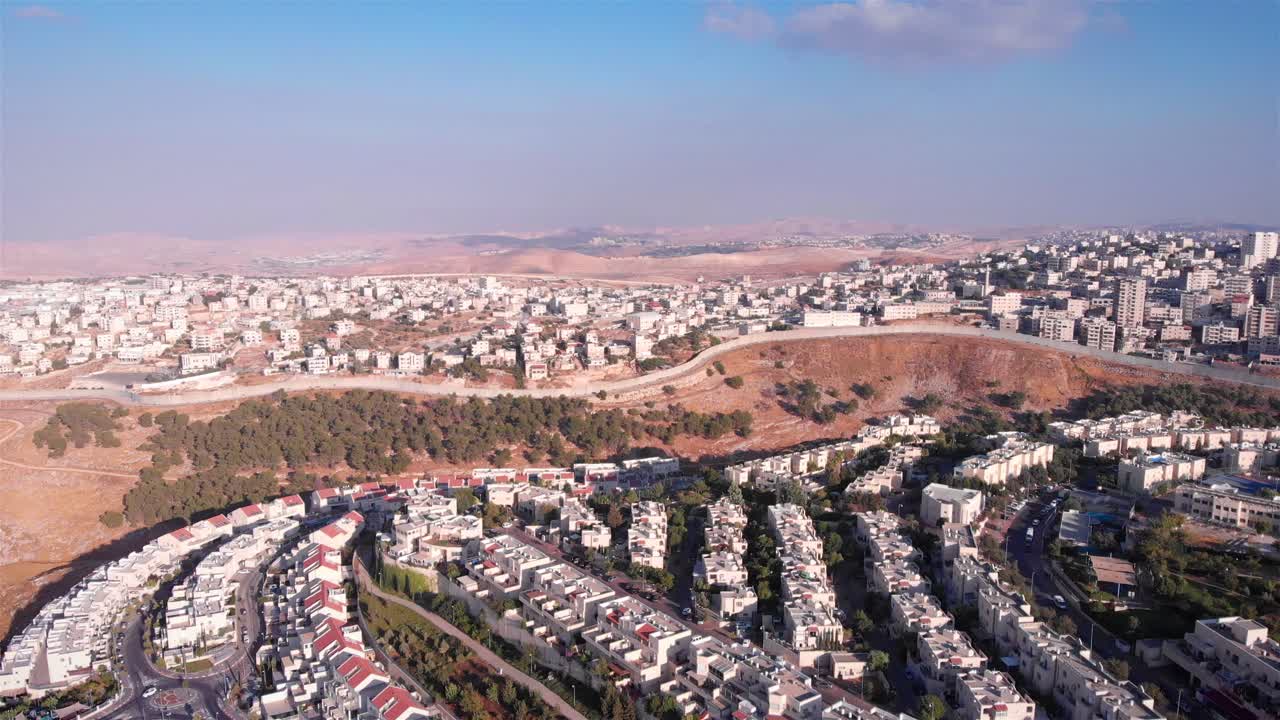 Aerial view of a city divided by a separation wall in the Middle East