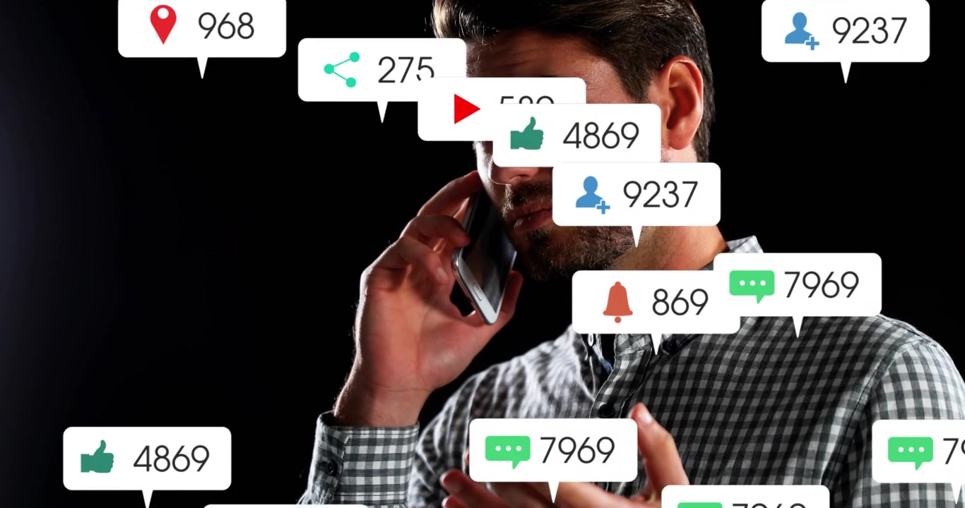 Mand i telefon under et teknisk opkald, lytter og gestikulerer, mens app-advarsler skaber bobler, der overlapper ham.