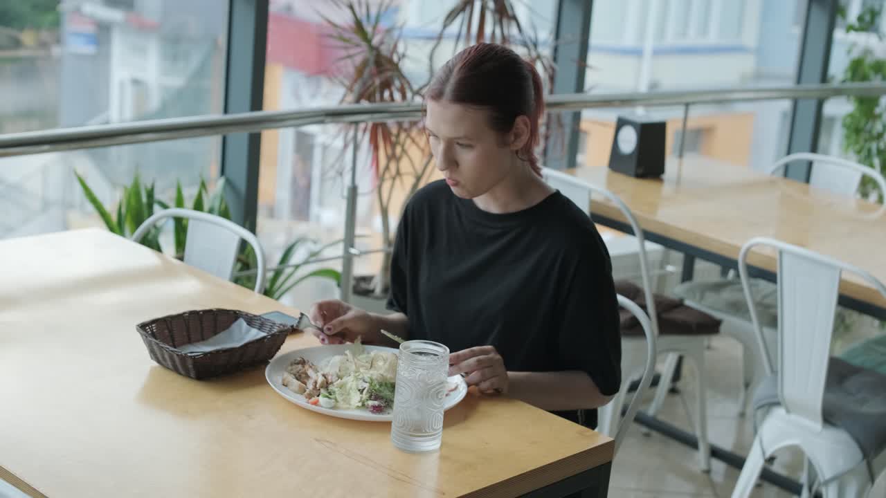mujer comiendo ensalada en un restaurante