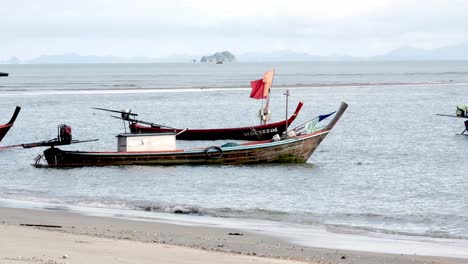 fishing boats moored along a windswept beach during the day in southern thailand