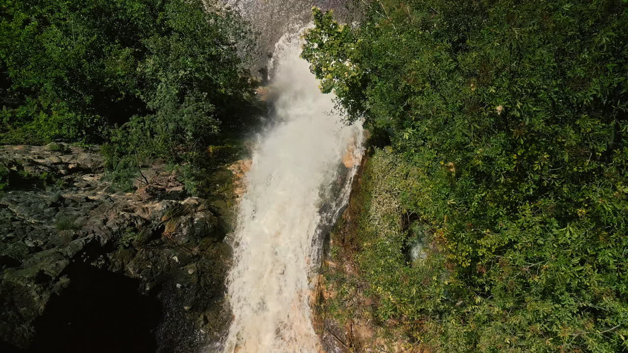 Powerful Waterfall Cascading Through Lush Green Forest