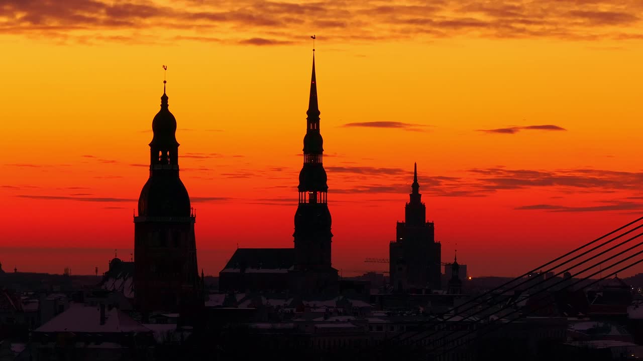 Majestic view of Riga's rooftops at sunrise with colorful clouds in silhouette