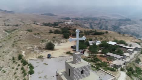 aerial spinning shot around white cross on top of church and valley view, bcharee, lebanon