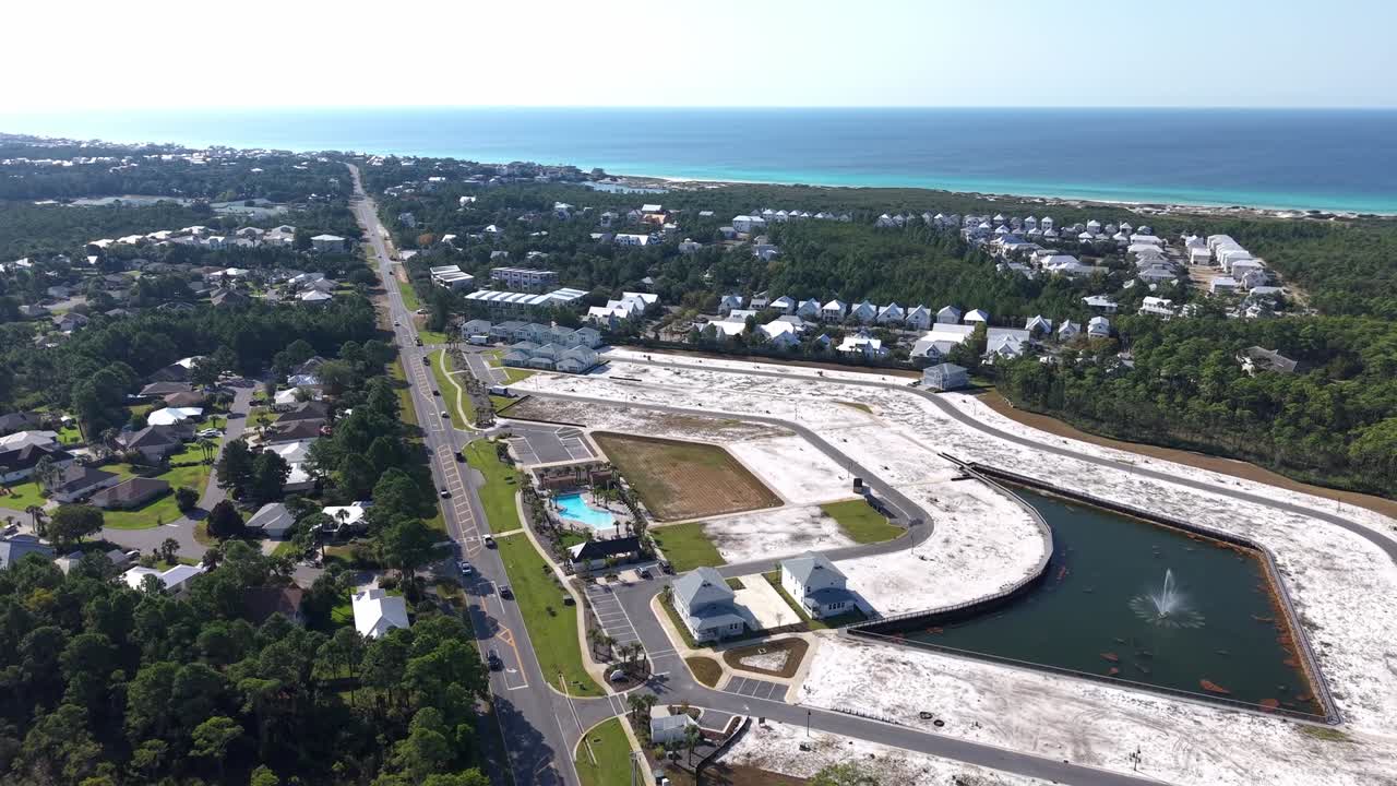 Panoramic drone fly at new residential community near coast on Dune Allen Beach construction areas and ocean in background, 30A, Florida, USA