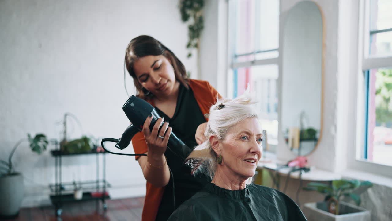 Hairstylist Blow Drying Senior Woman's Hair in a Modern Salon