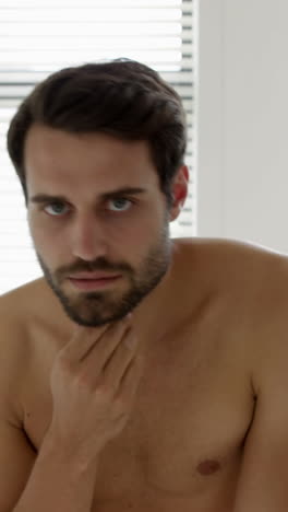 man checking his stubble in bathroom