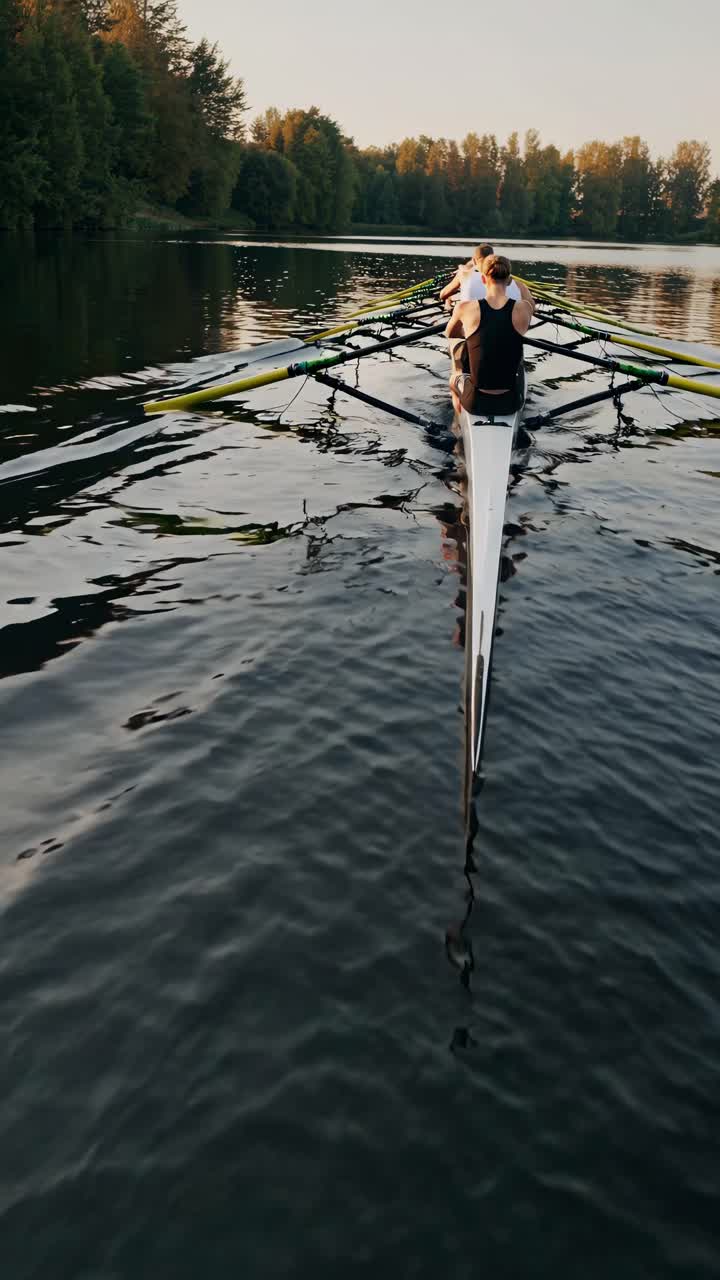 Roere i en elegant båd glider hen over en rolig sø omgivet af frodige træer