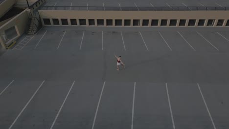 Drone-flying-over-ballet-dancer-on-parkade-roof