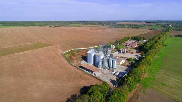 Storage silos on farm. Aerial view of grain silo in green field