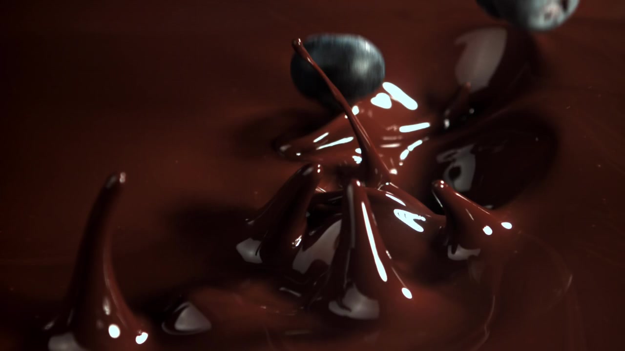 Mirtilli che cadono nel cioccolato fuso al rallentatore