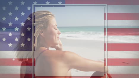 American-flag-with-glitch-effect-against-caucasian-woman-sitting-on-the-beach