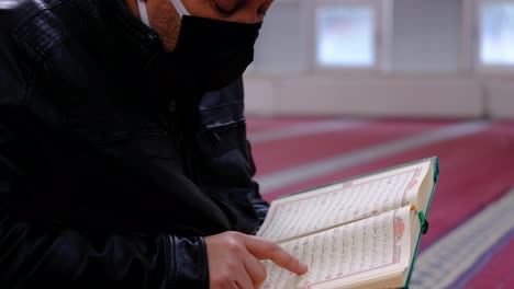 musulmán leyendo el libro sagrado del corán en una mezquita