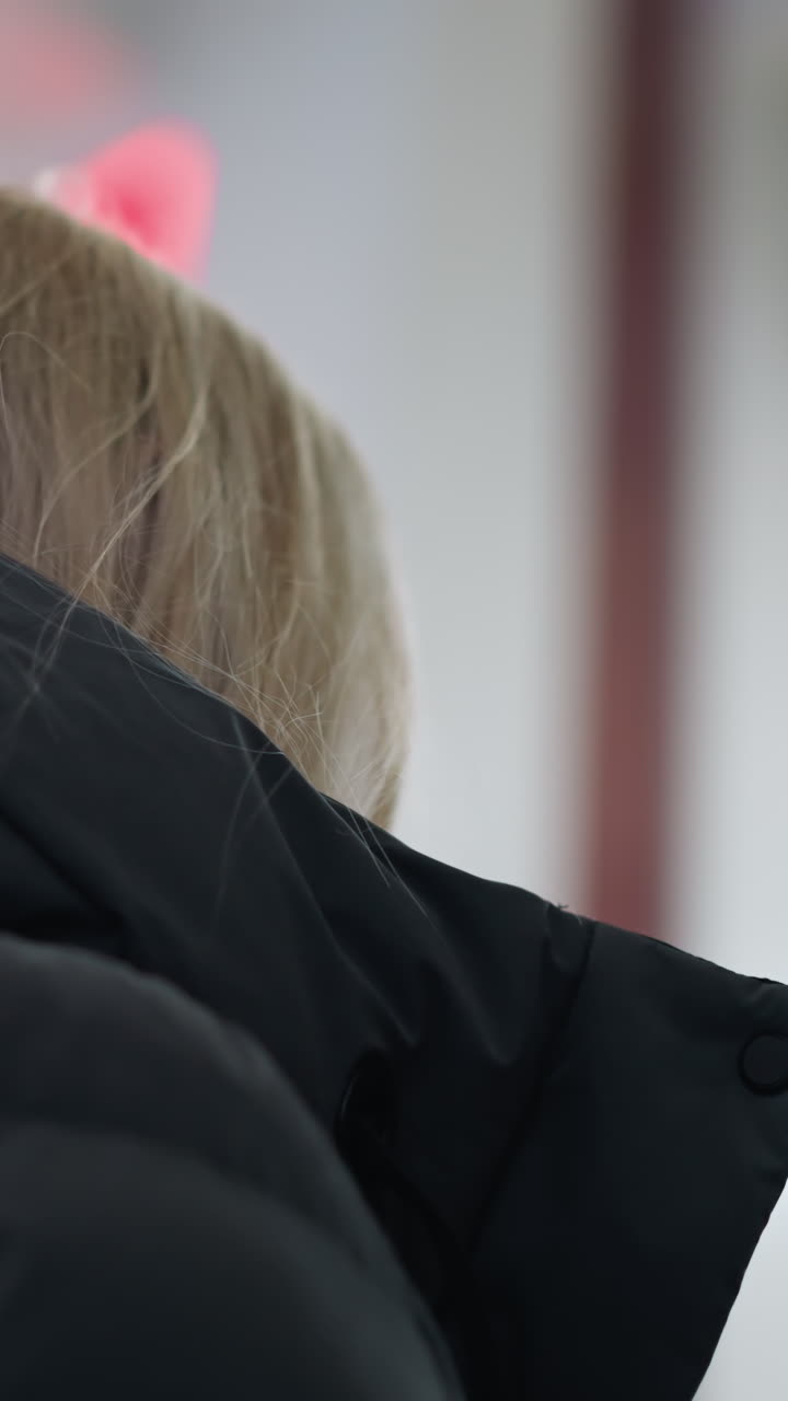 은 불빛이 박이는 흐릿한 배경과 함께 움직이는 에스컬레이터를 돌아보는 젊은 여성, 현대적인 도시 디자인과 움직임의 감각으로 매혹적인 관점