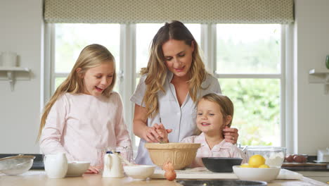 Madre-Y-Dos-Hijas-En-Pijama-Horneando-Juntas-En-La-Cocina-De-Casa