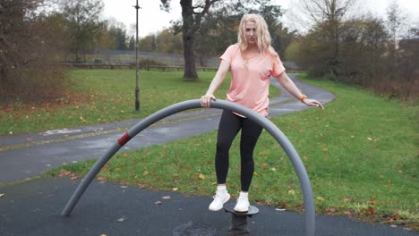 mujer atlética de cabello rubio realiza ejercicio de equilibrio al aire libre