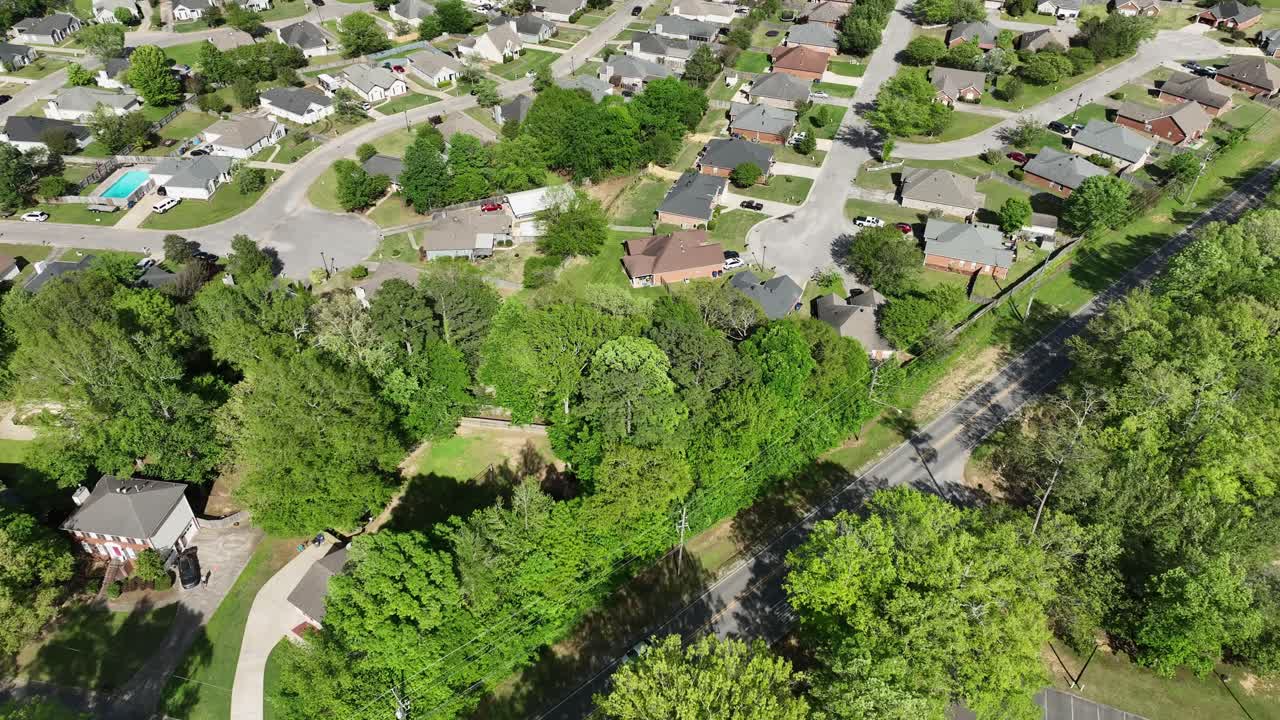 panorámica aérea de 4k del área suburbana con carreteras, casas y horizonte con cielo azul