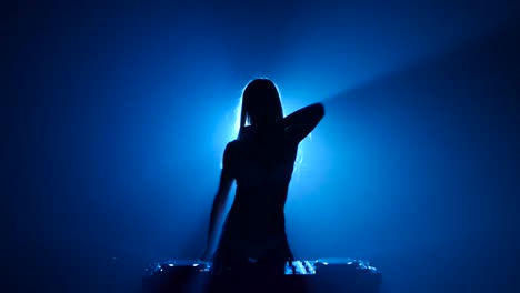 silhouette of a dj woman in blue light