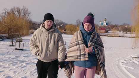 una pareja caminando en el parque de invierno.