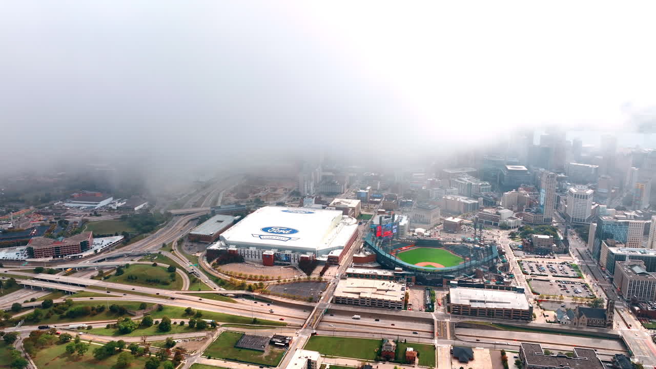 Detroit, USA, 28 July 2025: Foggy Aerial View of Detroit Sports Arenas and Downtown Core. An aerial view captures the Ford Field and Comerica Park arenas in the downtown core